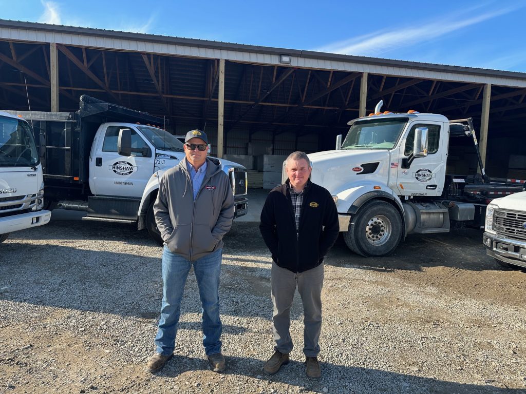 About 1 Brian & Nick standing in front of some trucks